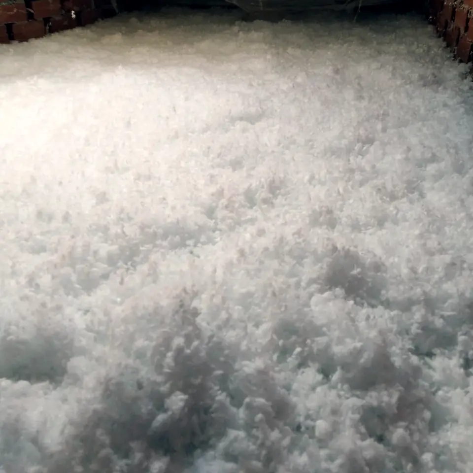 Lana mineral recién insuflada bajo una cubierta